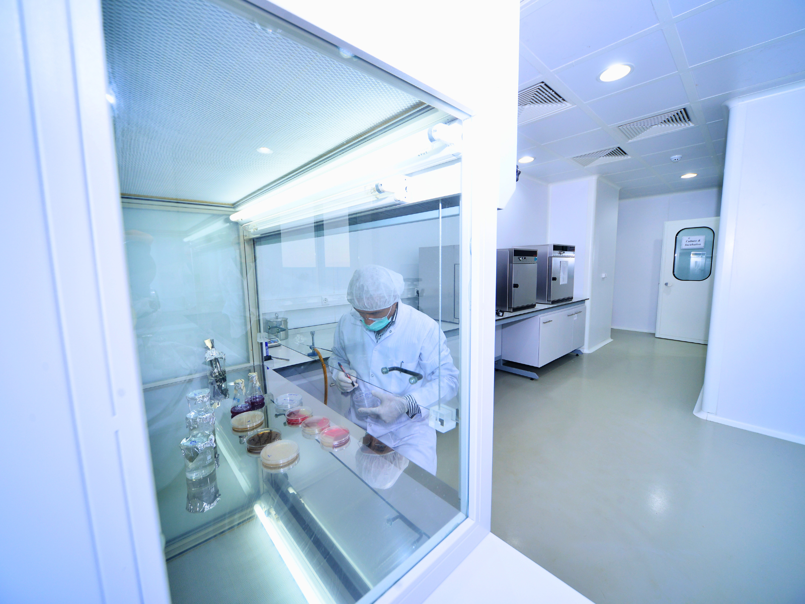 Laboratory technician working at a chemical fume hood with sash open during a containment evaluation