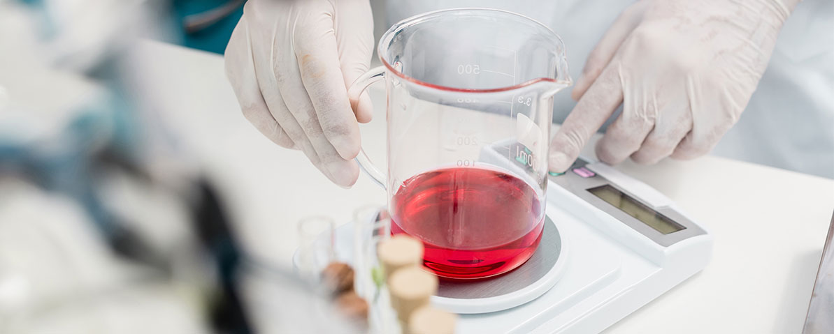 Liquid weighing on a top-loader balance — sample preparation in a quality-control laboratory